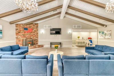 Bright common area with blue couches and fireplace