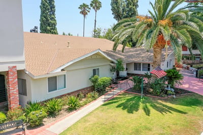 Exterior view of Leisure Vale Assisted Living with palm trees