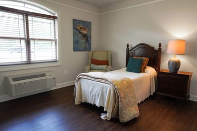 Cozy private room with a bed and armchair