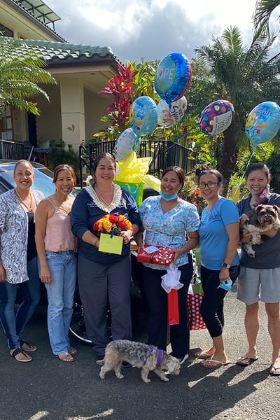 Staff members celebrating with balloons and flowers