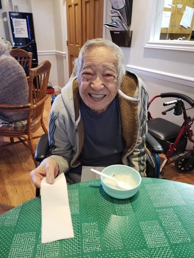 Resident smiling at a table with food.