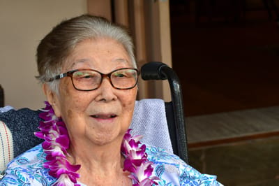 Senior resident smiling with a lei