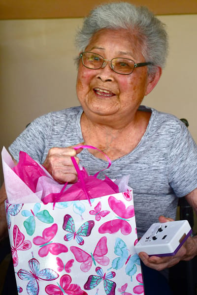 Resident smiling while holding a gift bag
