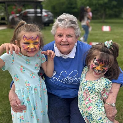 Senior resident with children enjoying a fun outdoor activity