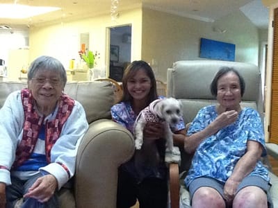 Residents and staff smiling together in a cozy living room