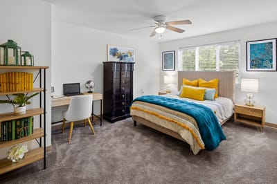 Well-decorated private resident room with a bed and desk