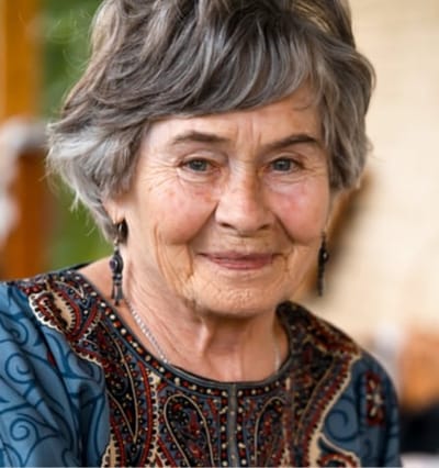 Elderly woman smiling warmly at the camera