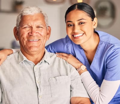 Staff member smiling with a resident in an indoor setting