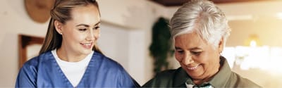 Caregiver assisting a senior resident in a bright activity area