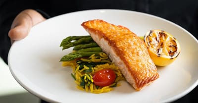 A plated meal featuring salmon, asparagus, and rice