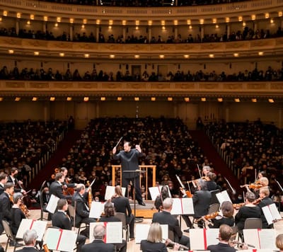 A full concert hall with an orchestra performing
