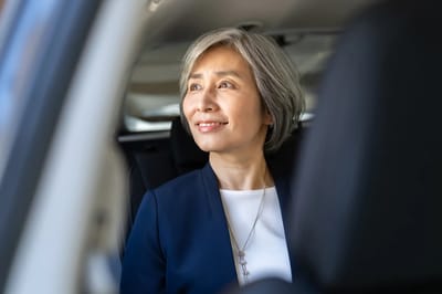 A senior woman smiling in a vehicle