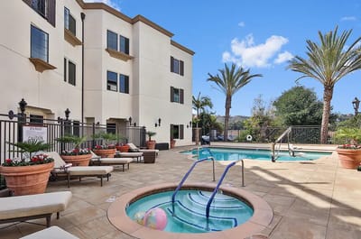 Outdoor pool area with lounge chairs and palm trees
