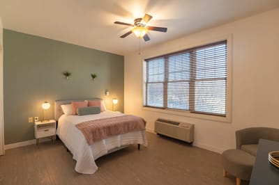 Bright private resident room with bed and seating area