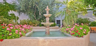 A garden area with a fountain and colorful flowers