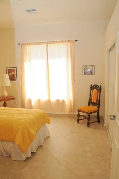 Cozy interior room with a yellow bedspread and chair