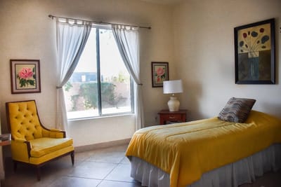 Brightly decorated private resident room with yellow accents