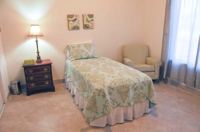 Cozy interior of a resident room with a bed and chair