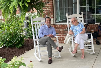 Guests enjoying a sunny day on a porch.