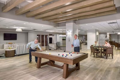 Residents enjoying a game of billiards in a common area.
