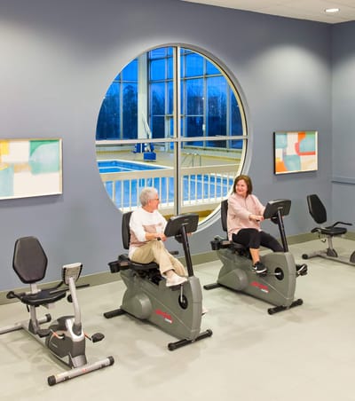 Residents exercising in an indoor fitness area.