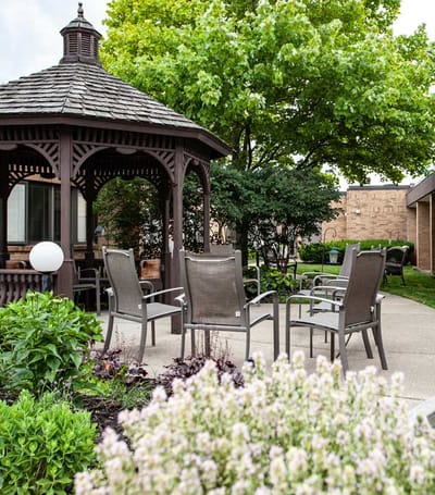 Outdoor gazebo with seating in a landscaped area