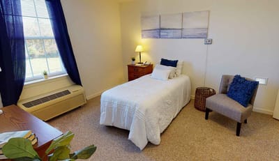 Cozy private resident room with a bed and chair