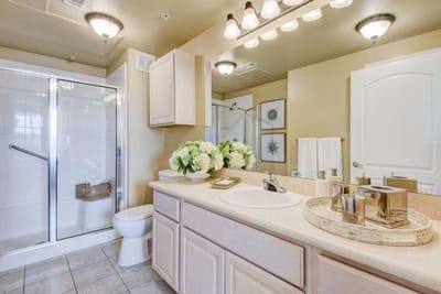 Well-lit bathroom with modern fixtures and flowers