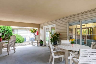Covered outdoor seating area with tables and plants