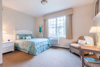 Cozy private resident room with a bed and chair