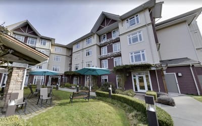 Exterior view of a senior living facility with outdoor seating