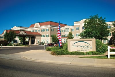 Exterior view of senior living facility with an American flag