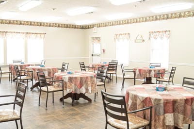 Interior dining area with tables set for residents