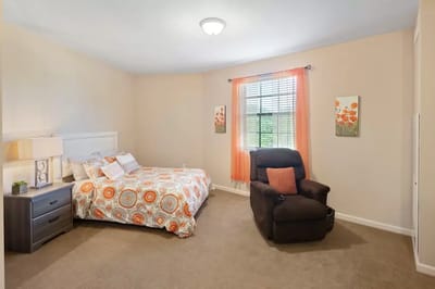 Cozy bedroom with a chair and decorative bedding