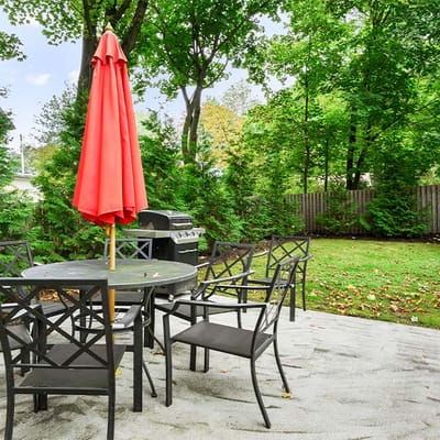 Outdoor patio area with a red umbrella and seating