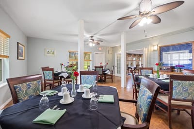 Dining area set up for a meal with flowers and table settings