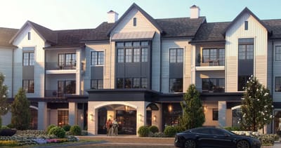 Exterior view of a senior living facility with people at the entrance