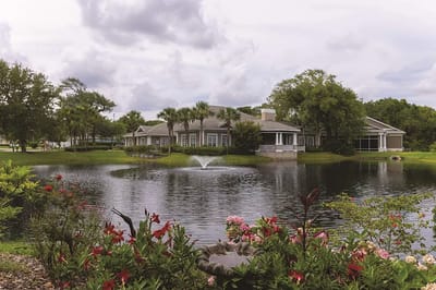 Pond view of the facility with landscaping
