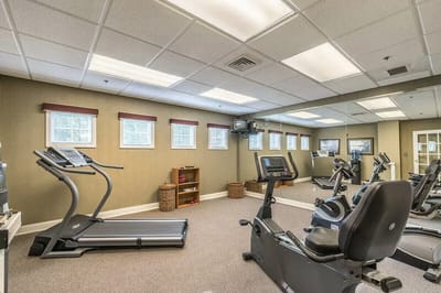 A gym area with exercise equipment and mirrors