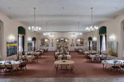 A spacious dining room with set tables and chairs