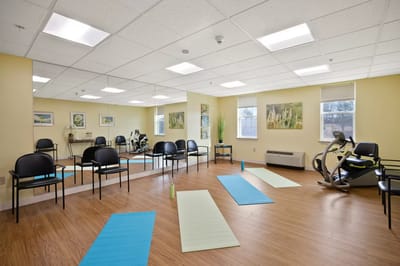 A bright, empty exercise room with yoga mats.