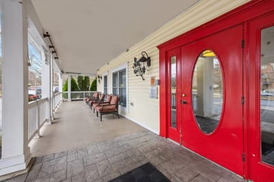 Entrance of a senior living facility with red door and seating