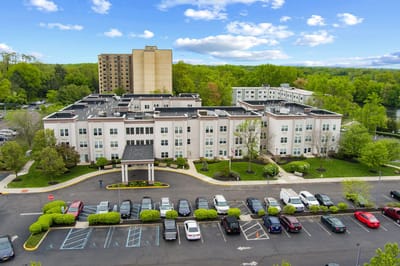 Aerial view of the facility with parking lot and greenery