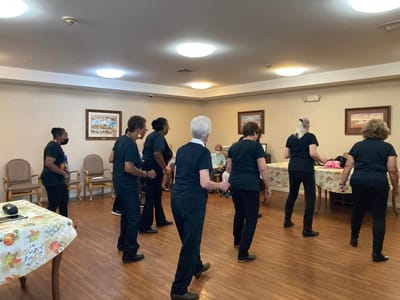 Residents and staff participating in a dance activity