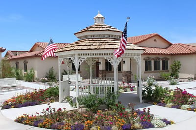 Gazebo surrounded by colorful flowers and American flags