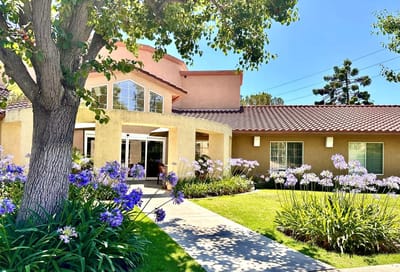 Exterior view of Villa Valencia Healthcare Center with flowers