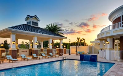 Outdoor pool area with lounge chairs and sunset