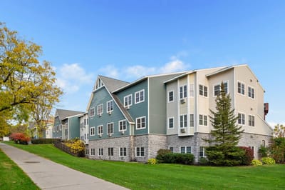 The Hearth on James NY, independent living in Syracuse, NY — Modern senior living facility with landscaped grounds and blue sky
