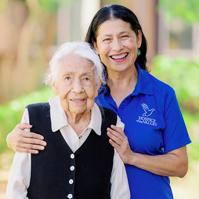 Caregiver and resident smiling outdoors