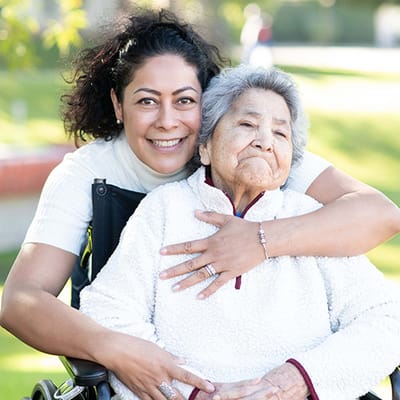 Caregiver and resident smiling together outdoors